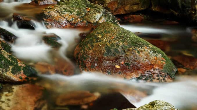 Wasser, das nebelig über Steine fließt