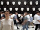 Frau vor einer Maskenwand