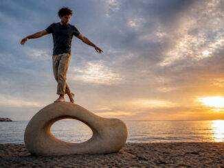 Balance an Strandskulptur bei Sonnenuntergang