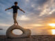 Balance an Strandskulptur bei Sonnenuntergang